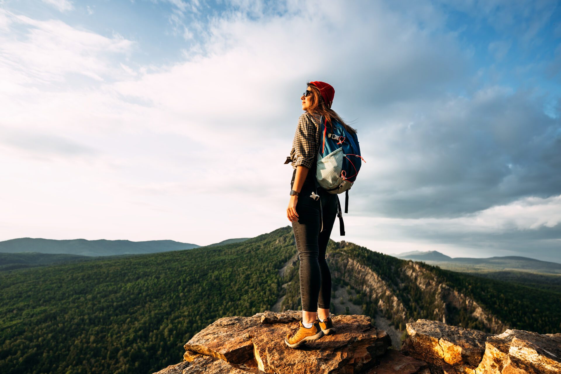 A woman meets the sunset in the mountains.